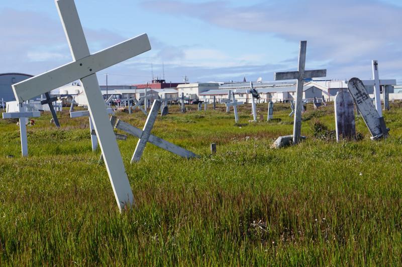 Grave markers in Utqiagvik's cemetery, seen on Aug. 6, are tilted, a sign of thaw in the ground below. Permafrost thaw impacts extend to the dead. (Photo by Yereth Rosen/Alaska Beacon)